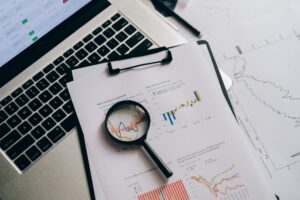 Servicios Overhead view of financial charts, laptop, and magnifying glass, ideal for business analysis themes.
