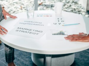Servicios Two professionals collaborate on marketing strategy and segmentation at a round table.